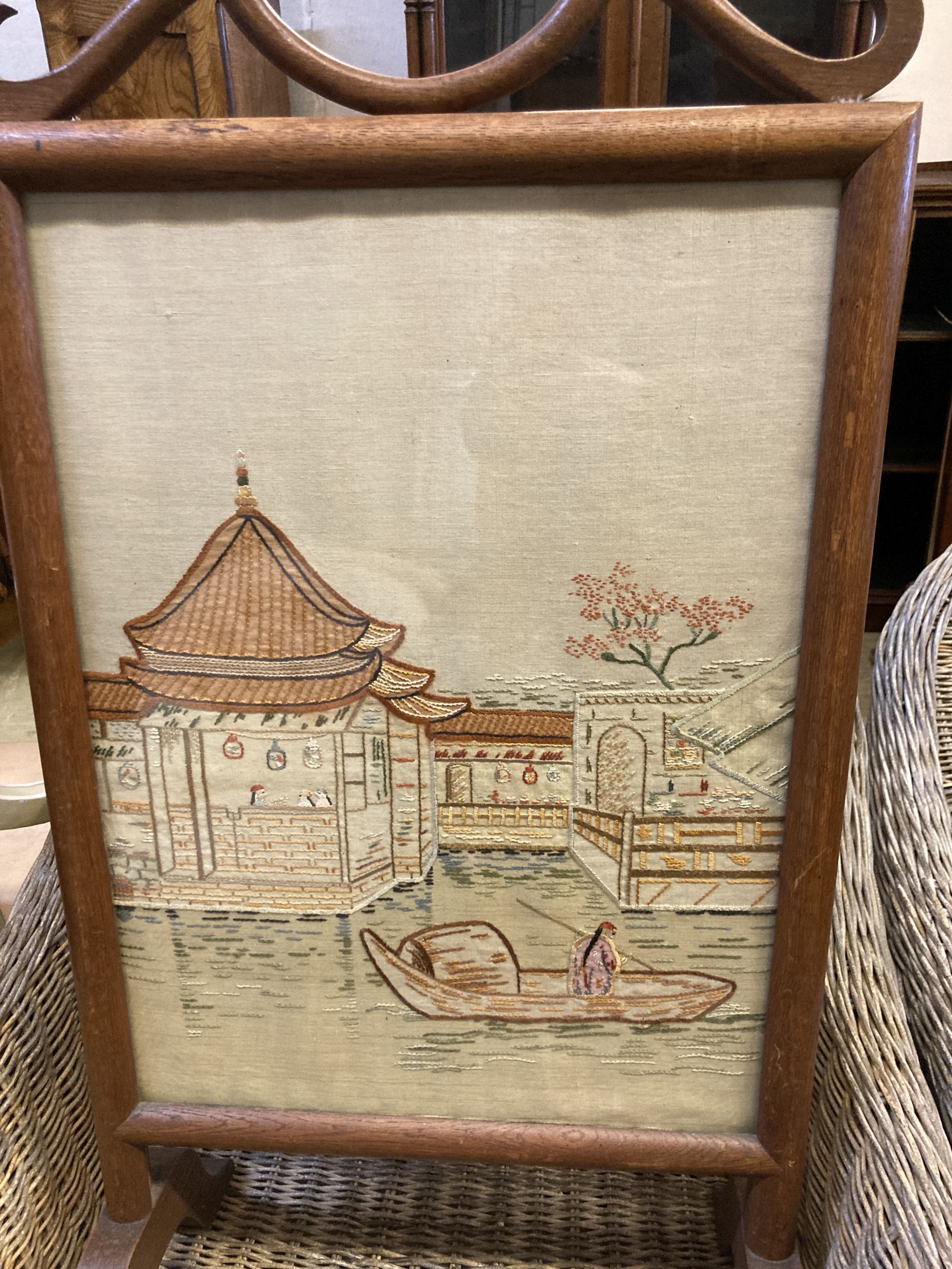 An Arts & Crafts rectangular chip carved oak stool, width 43cm, depth 34cm, height 38cm, together with an embroidered firescreen